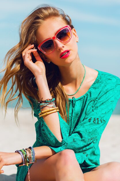 日当たりの良い熱帯のビーチでポーズクールなサングラスでかなり若い金髪の美しい女性の肖像画