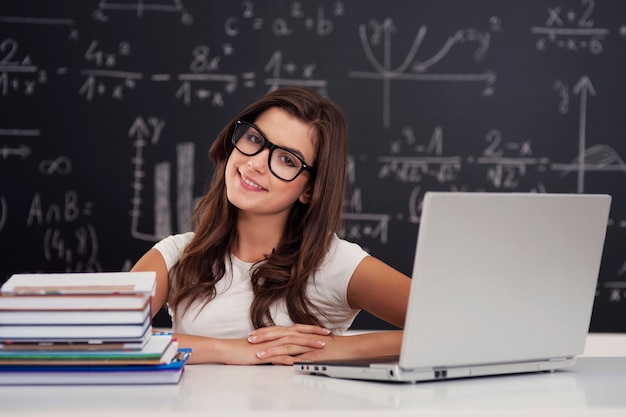 Portrait of pretty young female student in classroom
