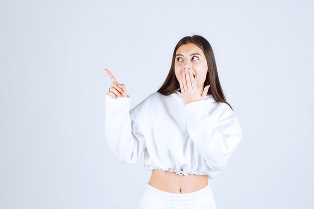 Portrait of pretty young girl model posing and pointing away.