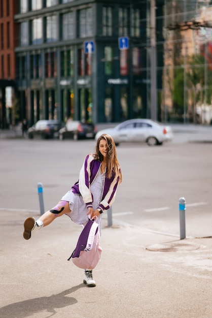 Portrait of pretty young woman having fun at the street