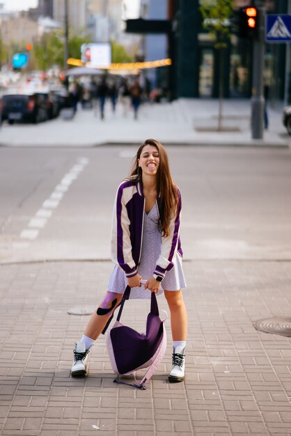 Portrait of pretty young woman having fun at the street