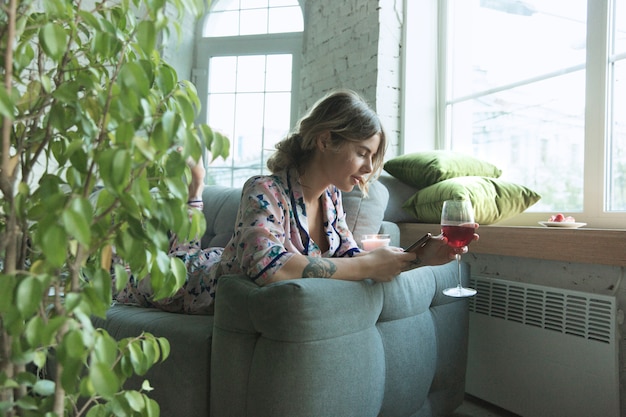 Free photo portrait of pretty young woman in modern apartment in the morning. resting, calm, salisfied. youth and wellness concept.