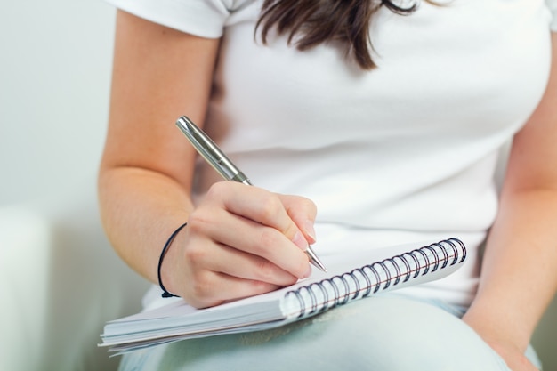 Portrait of pretty young woman taking notes