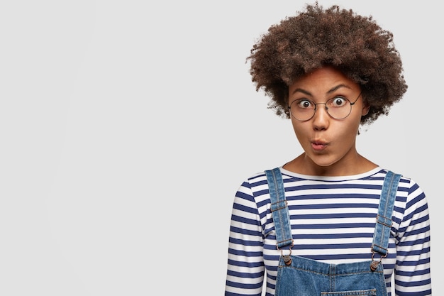 Free photo portrait of puzzled dark skinned young female with curly hair