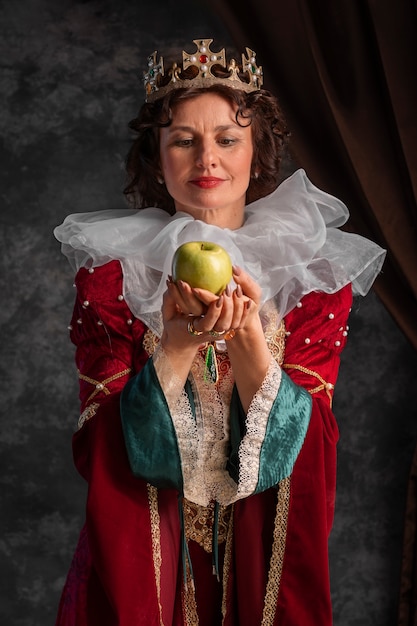 Free photo portrait of queen with crown and apple fruit