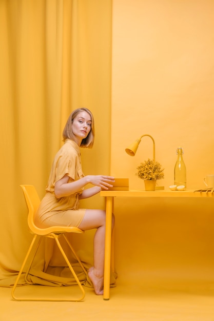 Free photo portrait of  reading woman in a yellow scene