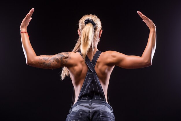 Portrait rear view of a beautiful athletic woman on dark