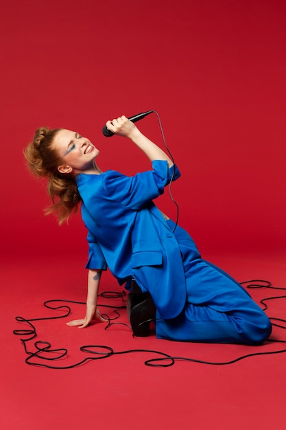 Portrait of redhaired singing woman with micorphone
