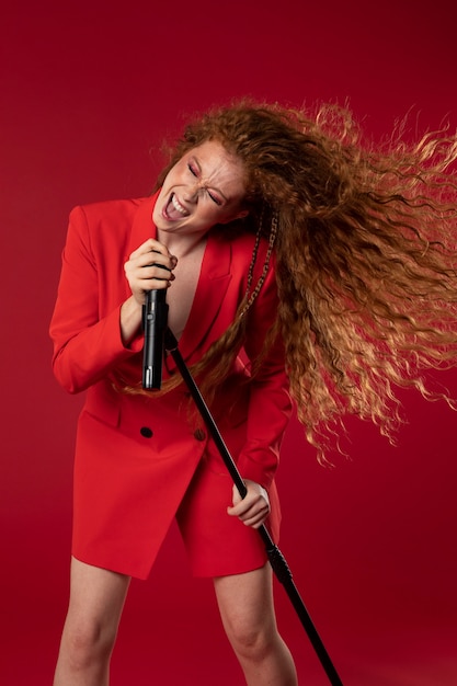 Portrait of redhaired singing woman with micorphone