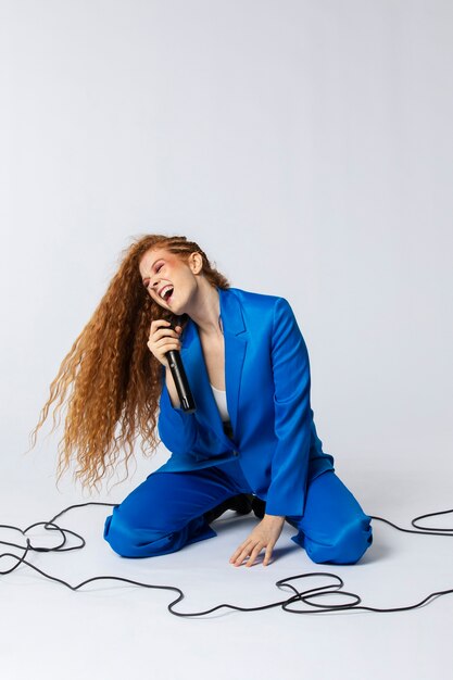 Portrait of redhaired singing woman with micorphone