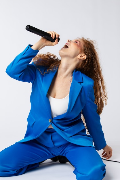 Ritratto di donna che canta dai capelli rossi con il microfono