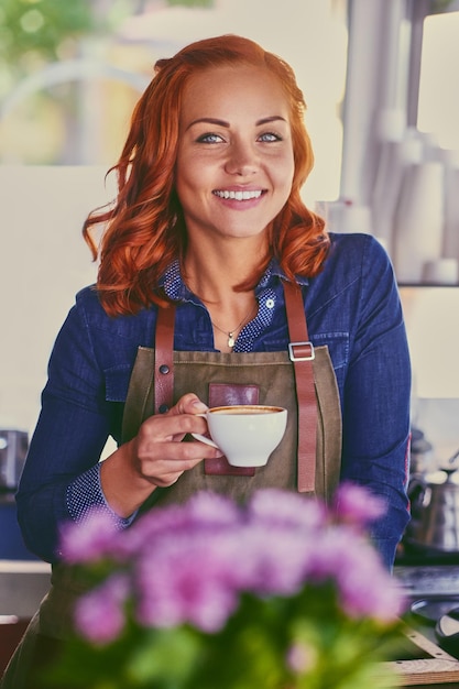 小さなコーヒーショップで赤毛の女性バリスタの肖像画。