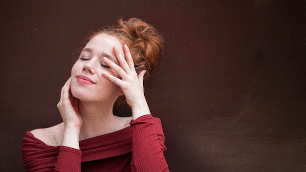 Portrait of redhead girl on brown background