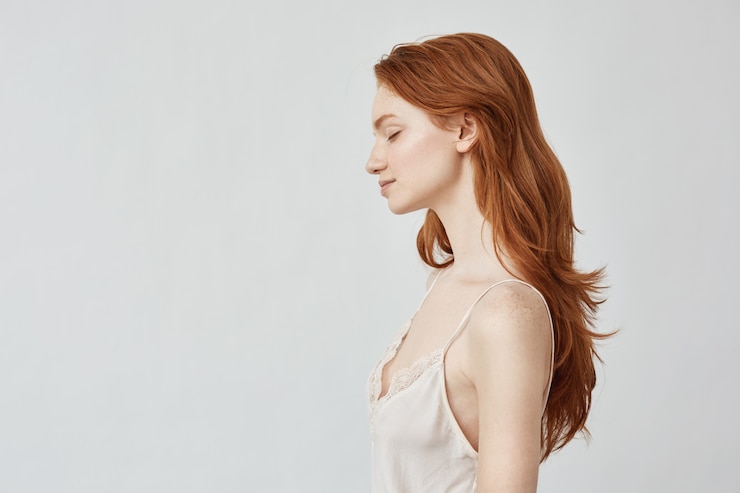 Free Photo portrait of redhead girl in profile with closed eyes smiling.