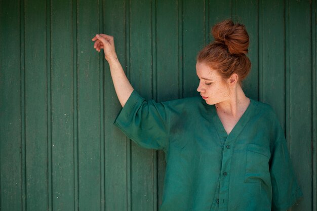 Portrait of redhead woman on green background