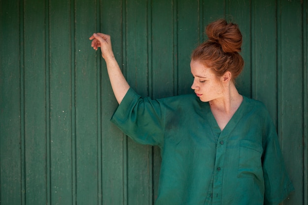 Portrait of redhead woman on green background