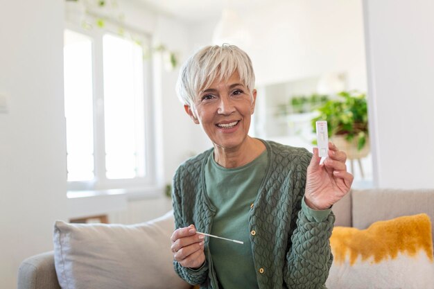 Portrait of relaxed mature woman taking a Selfswabbing home tests for COVID19 at home Senior woman using cotton swab while doing coronavirus PCR test at home Quarantine pandemic
