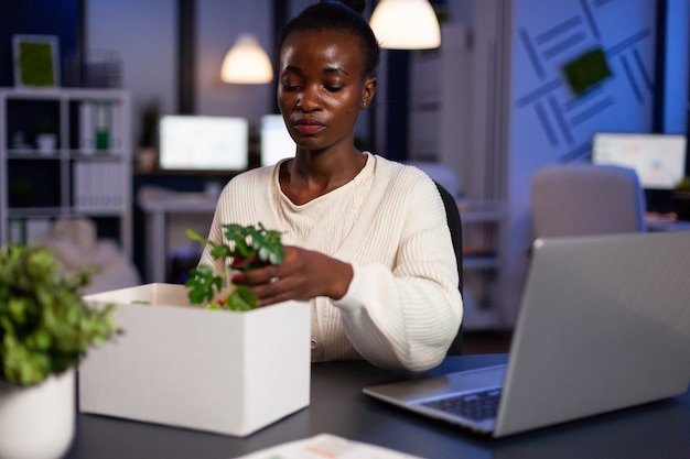 Portrait of resigned dismissed african american businesswoman packing objects