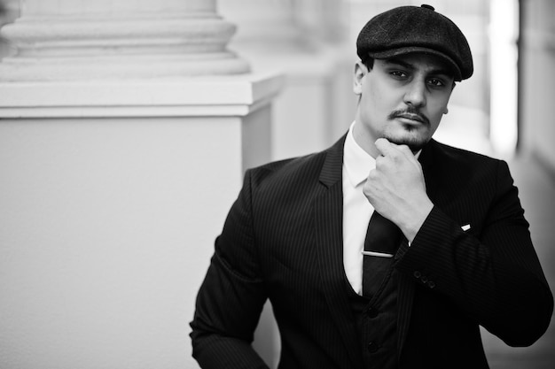 Портрет английского арабского бизнесмена ретро 1920-х годов в темном галстуке и плоской кепке