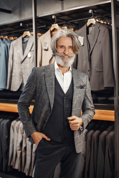 Portrait of a rich mature man. Senior visiting a fashion boutique. Male buy a new exclusive costume.