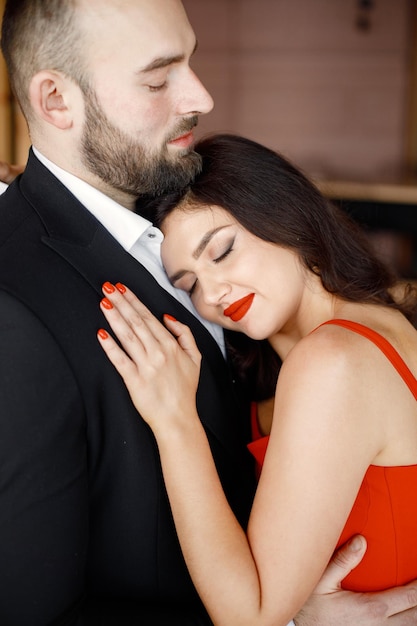 Портрет романтической пары, стоящей в ресторане на свидании и обнимающейся