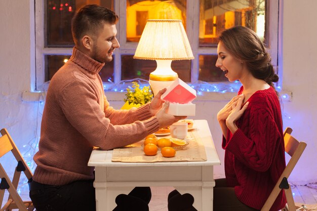 Portrait of romantic couple at Valentine's Day dinner with  gift