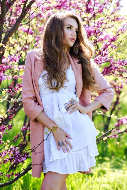 Portrait romantic sensitive young woman with long hair in pink coat