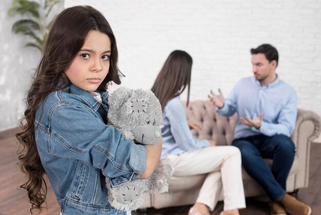 Portrait of sad girl holding teddy bear