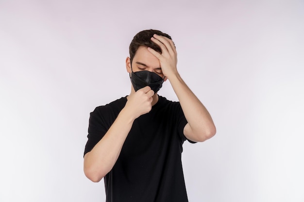 Portrait of sad and sick young man in a flu mask isolated over white background