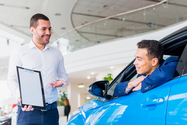 Free photo portrait of salesman in car dealership