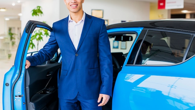 Free photo portrait of salesman in car dealership