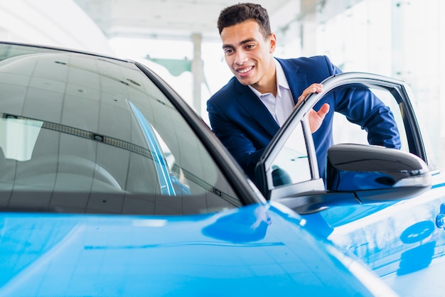 Free photo portrait of salesman in car dealership