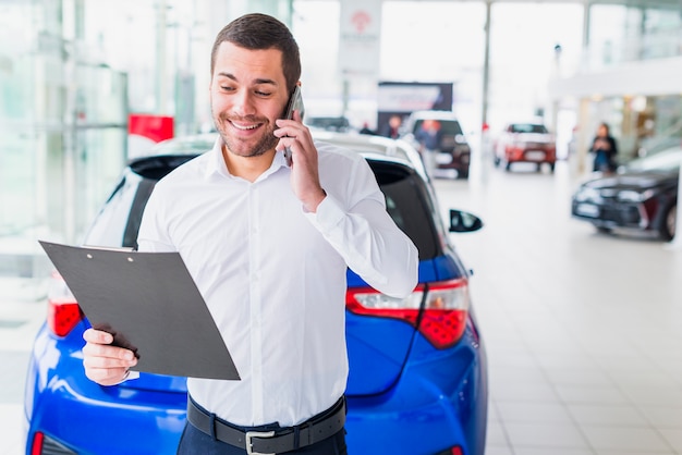 Free photo portrait of salesman in car dealership