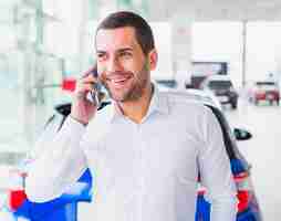 Free photo portrait of salesman in car dealership