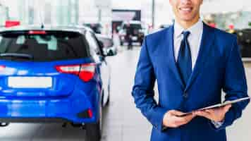 Free photo portrait of salesman in car dealership