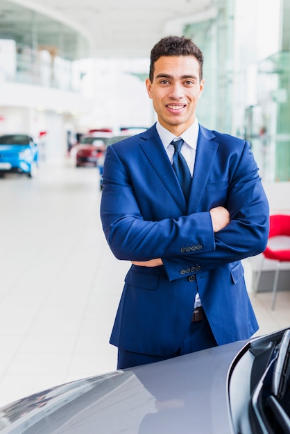 Free photo portrait of salesman in car dealership