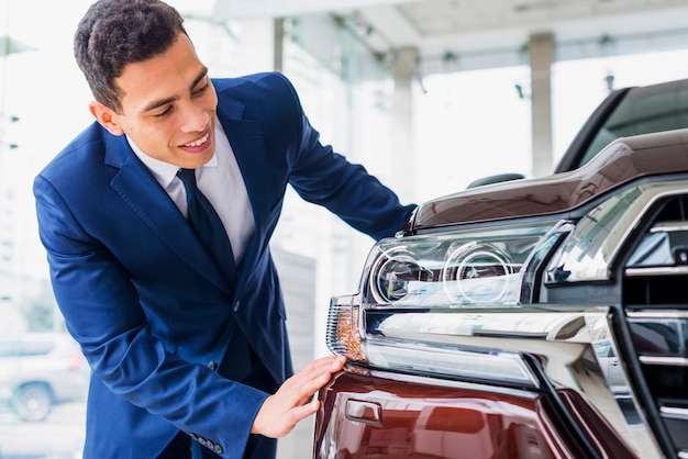 Free photo portrait of salesman in car dealership