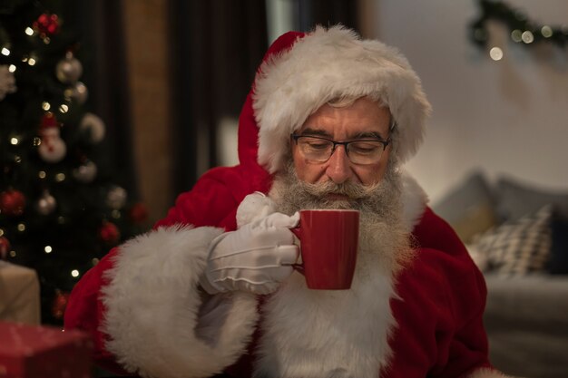 Portrait of santa claus having a christmas drink