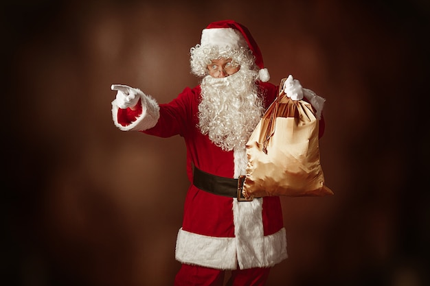 Foto gratuita ritratto di babbo natale in costume rosso con sacchetto regalo