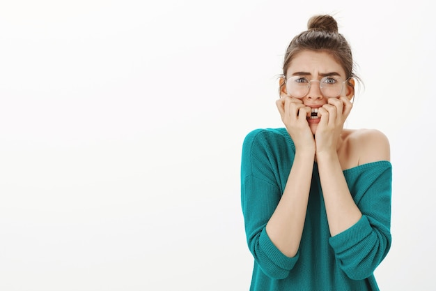 Foto gratuita ritratto di giovane donna spaventata e intimidita con gli occhiali che si sente spaventata, che sembra inorridita