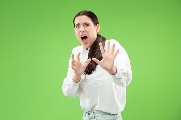 Portrait of the scared woman. Business woman standing isolated on trendy green  wall. Female half-length portrait. Human emotions, facial expression concept