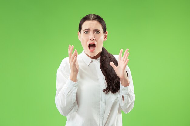 Portrait of the scared woman on green wall