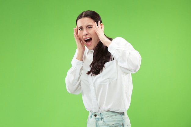 Portrait of the scared woman on green