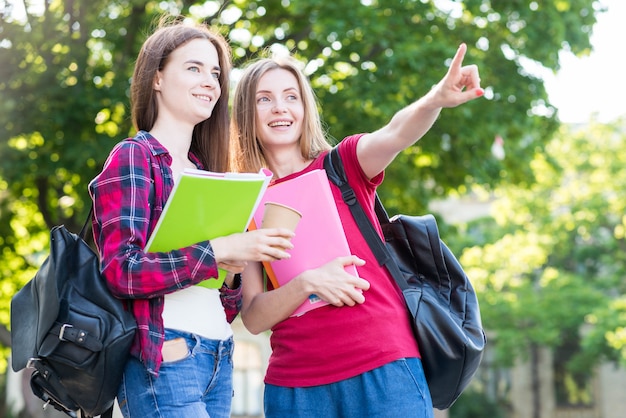 Portrait of school girls with books in park