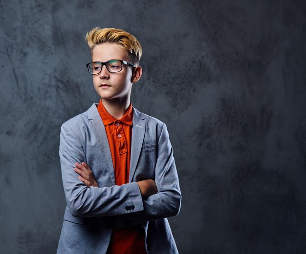 Portrait of schooler teenage boy in eyeglasses dressed in a stylish jacket.