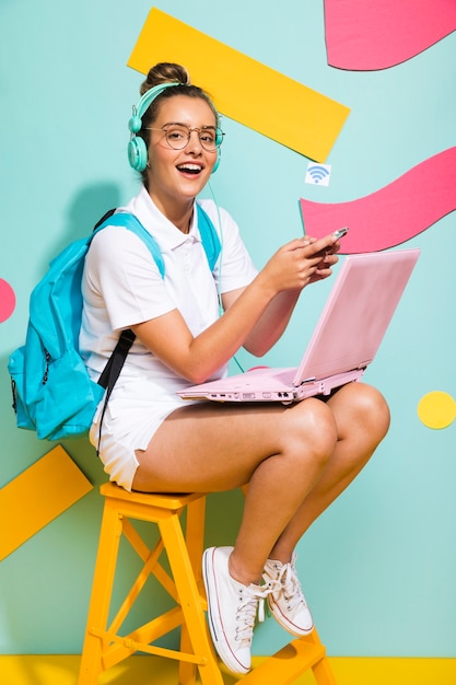 Ritratto della scolara che studia con il computer portatile