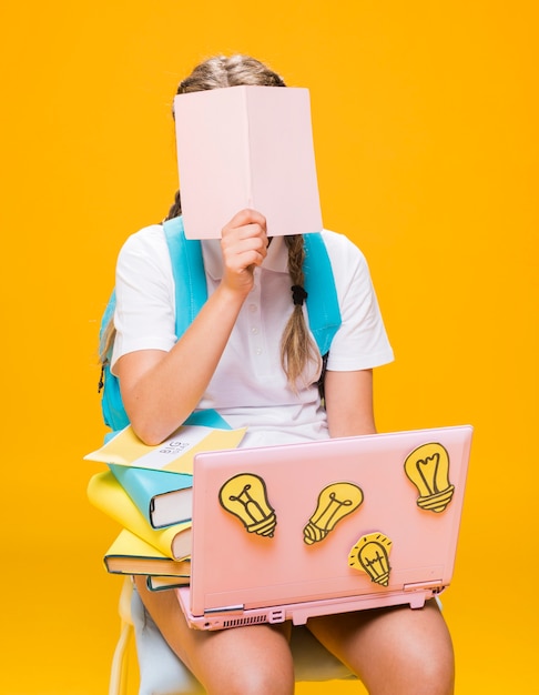 Foto gratuita ritratto della scolara che studia con il computer portatile