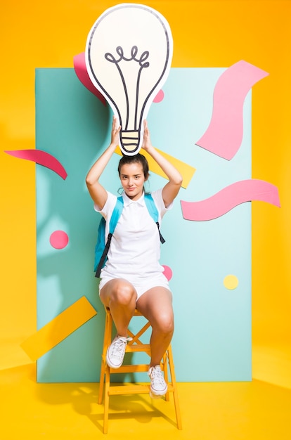 Free photo portrait of schoolgirl with big light bulb