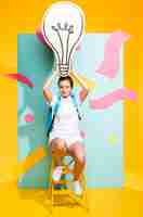 Free photo portrait of schoolgirl with big light bulb