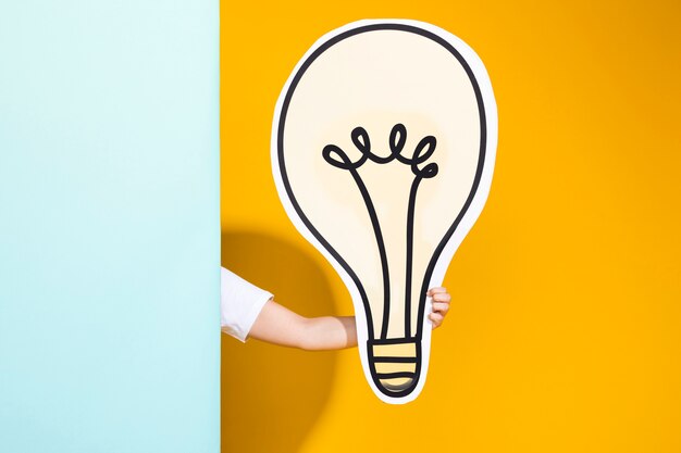 Portrait of schoolgirl with big light bulb